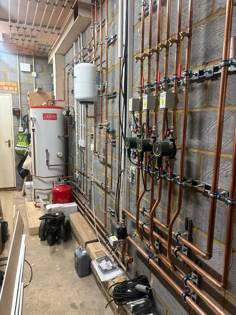 Central heating plant room with hot water cylinders, pumps and copper pipework installed by C Hobbs Plumbing and Heating